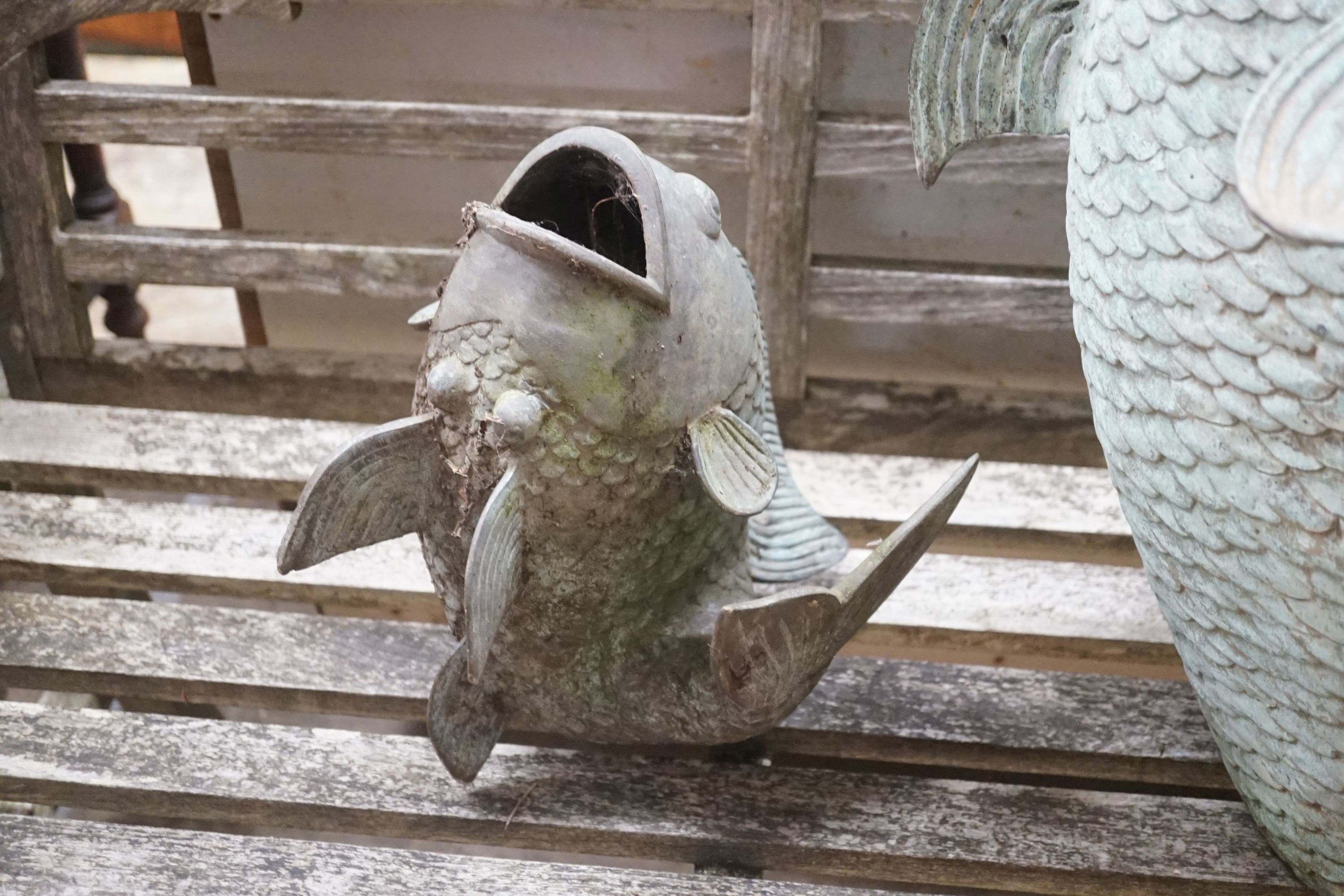 Three cast metal carp garden ornaments, largest 60cm height 46cm